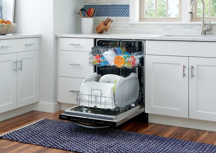 full dishwasher with the door open in a kitchen 