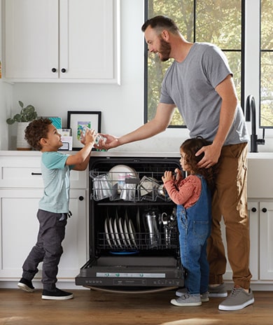 kids and father loading the dishwasher