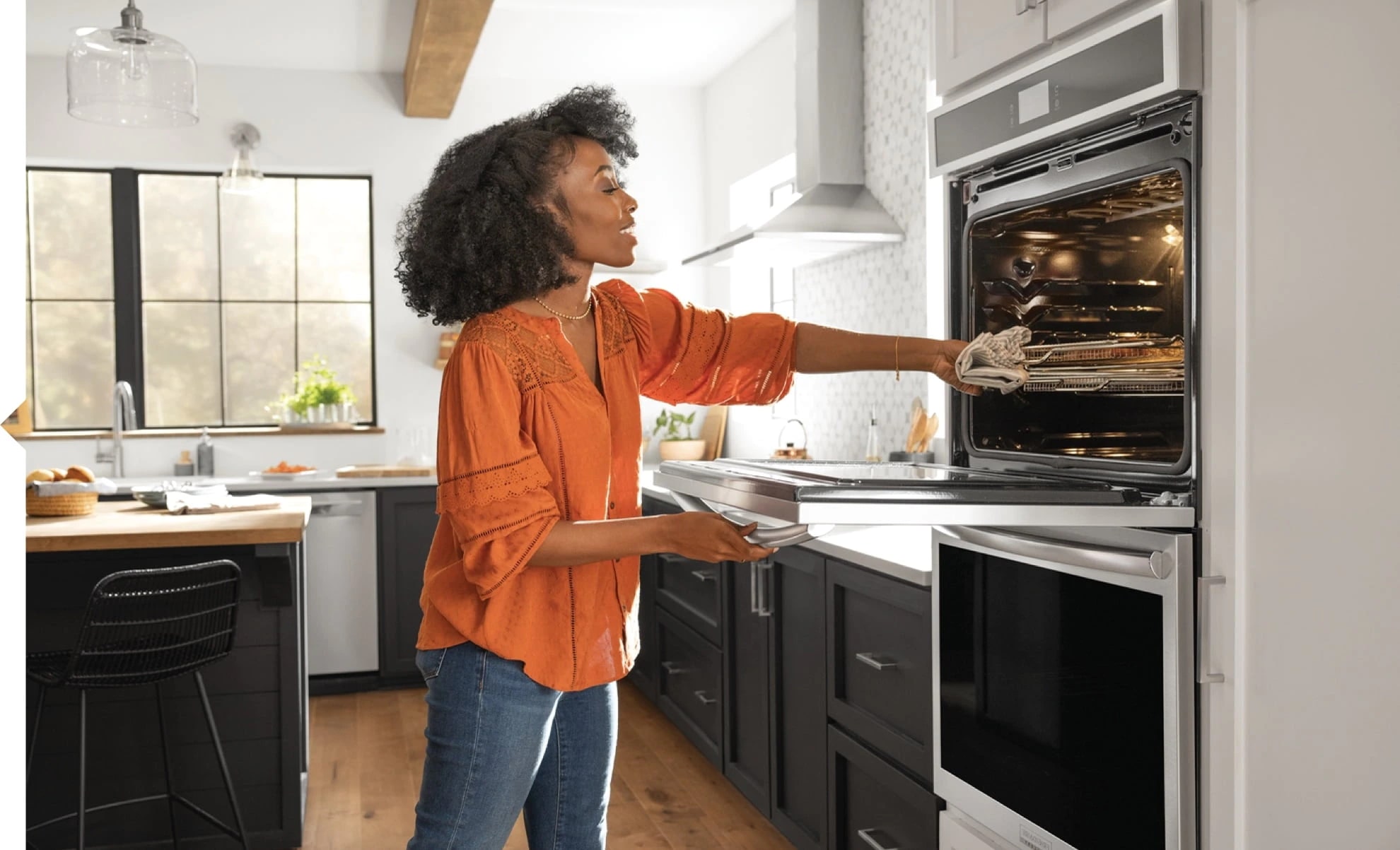 Woman grabbing food out of Wall Oven