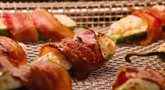 Bacon wrapped jalapeno popper bubbling in the oven